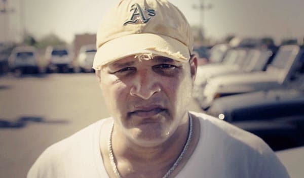 Mark Kerr, 46, stands in a Phoenix area used car lot where he once worked.
